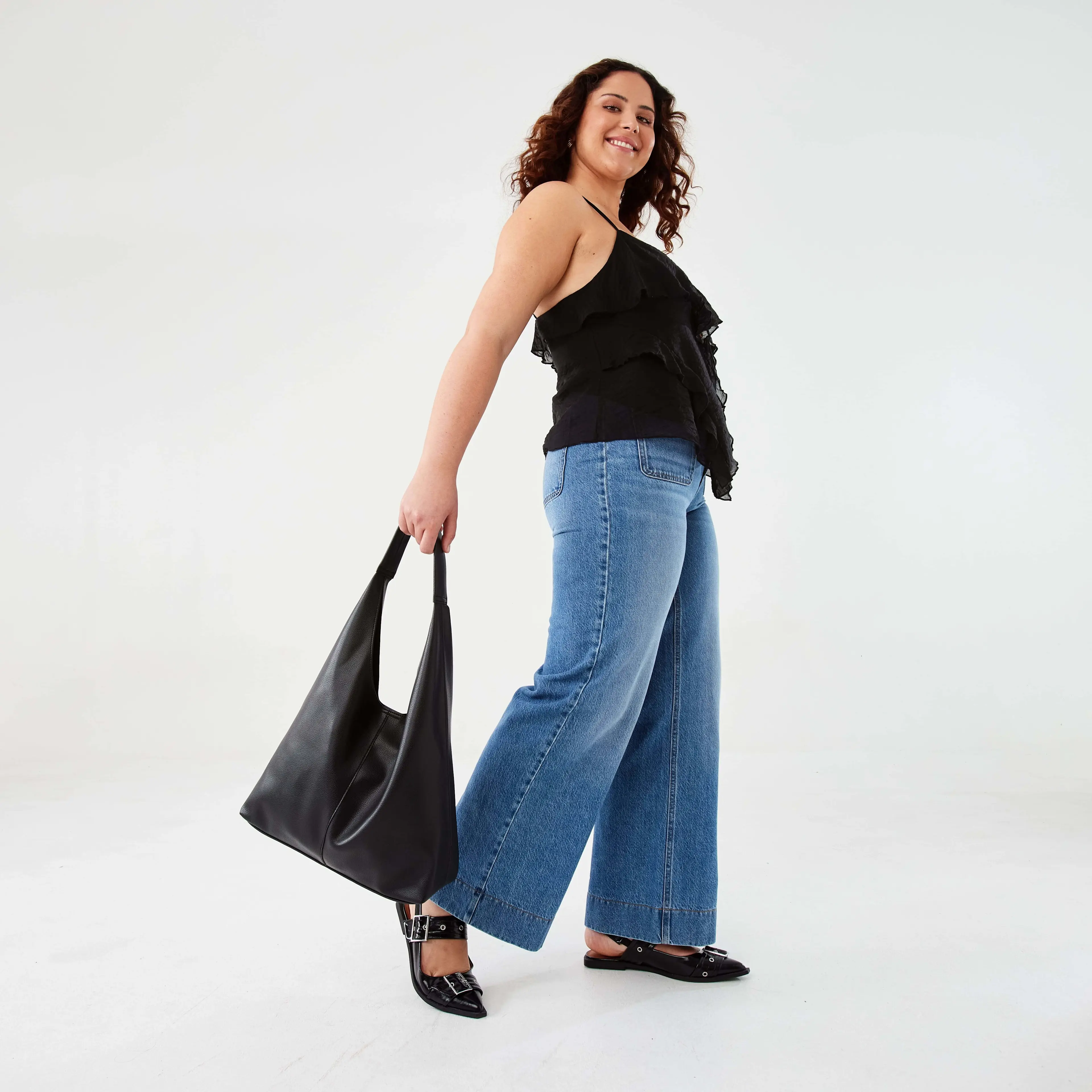 Woman Wearing Wide Leg Pocket Jeans with Black Ruffle Cami 