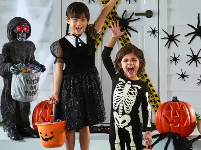 Young Girl and Boy Wearing Halloween Costumes