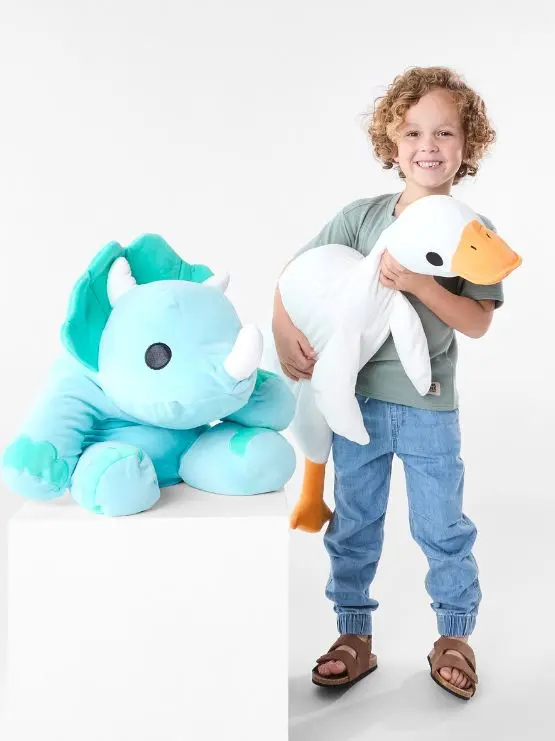 Young boy holding a giant plush duck