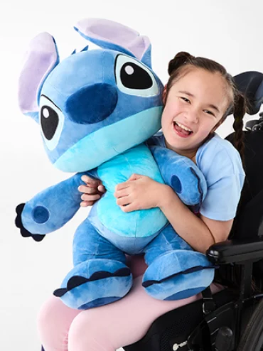 Young girl holding Disney Lilo & Stitch Walking Plush