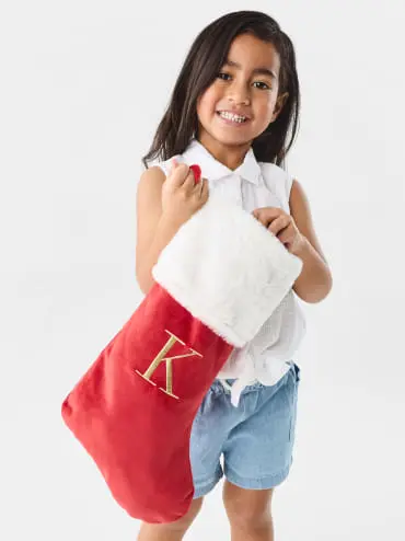 Little girl holding a Christmas Stocking with the Letter K o