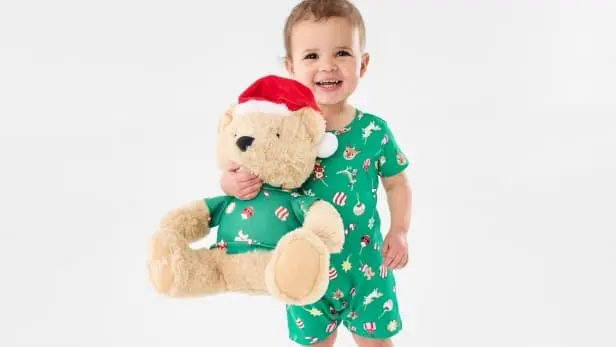 Little boy cuddling Kenzie bear toy and wearing the Kenzie bear themed pyjamas