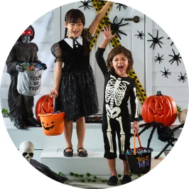 Little boy and girl dressed up in Halloween costumes trick or treating toge