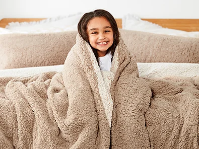 young girl wrapped up in a fluffly blanket
