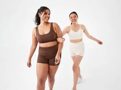 two women wearing brown and white activewear sets