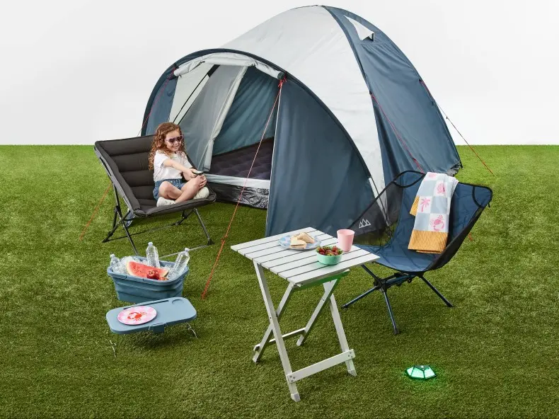 camping tent with young girl sitting on a camping chair