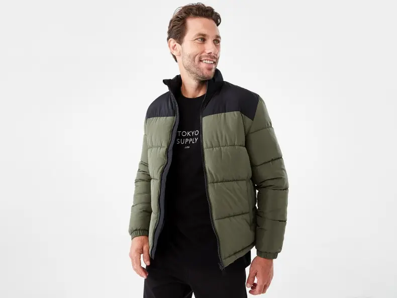 man wearing a green and black puffer jacket