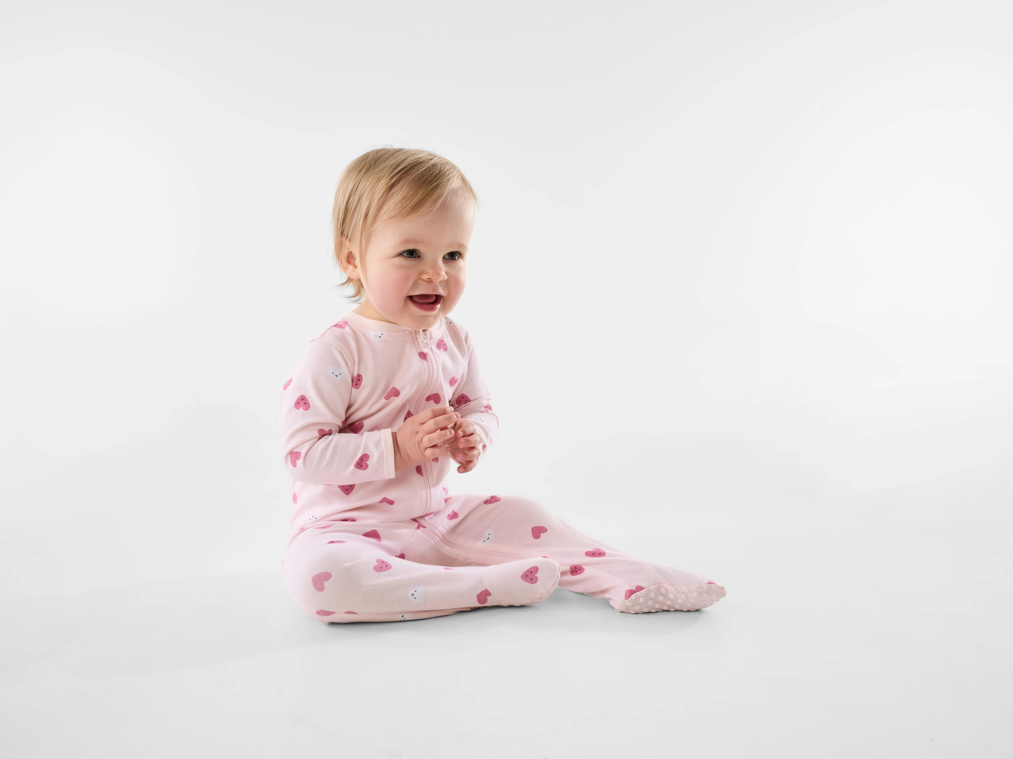 Baby boy in a heart pink coverall