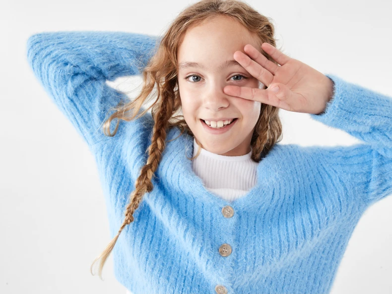 young girl wearing a blue knit top