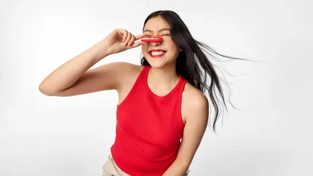 Talent holding OXX Lipstick in Red shade