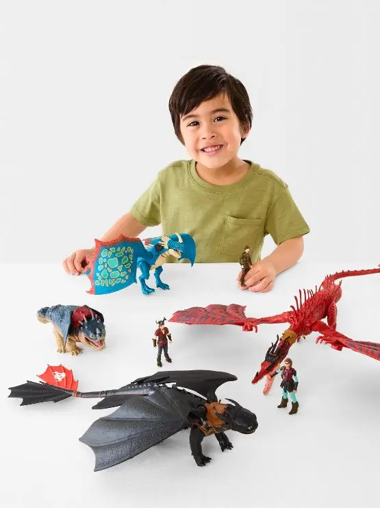 Boy with assorted action figures of dinosaurs and dra