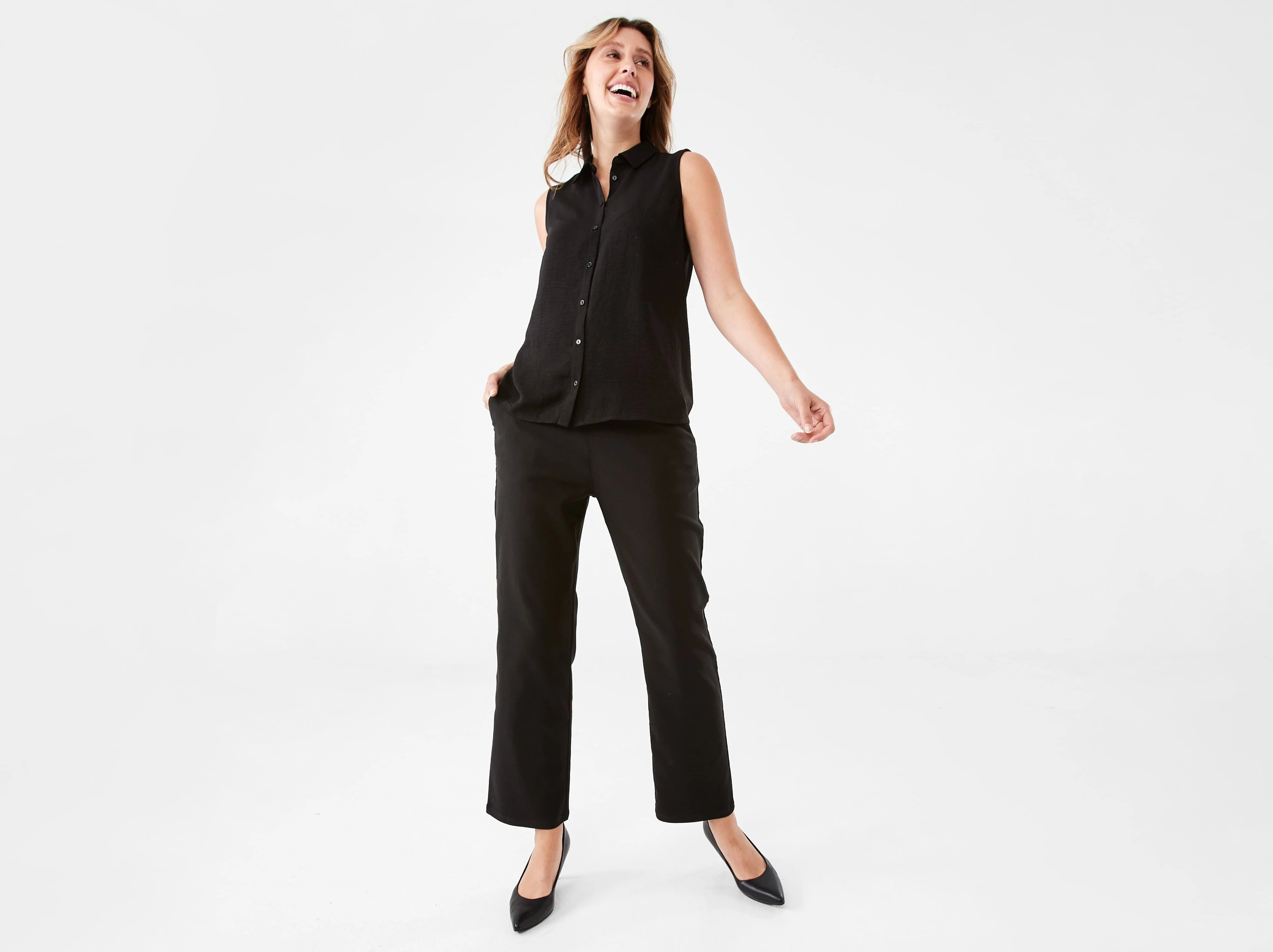 a woman wearing smart casual with a black top, black pants and black flat s
