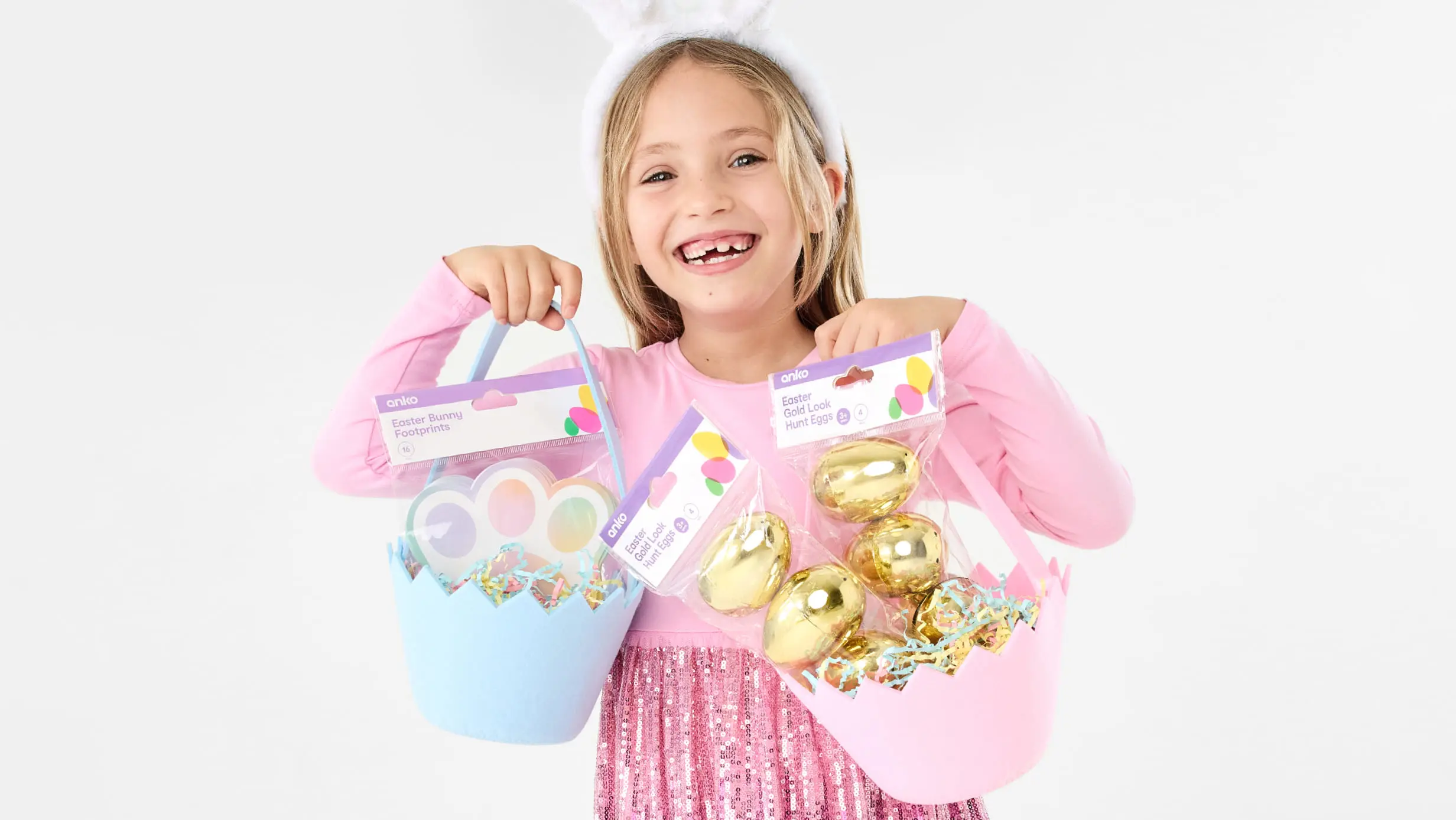 Little girl holding easter baskets with Easter egg hunt goodies in them