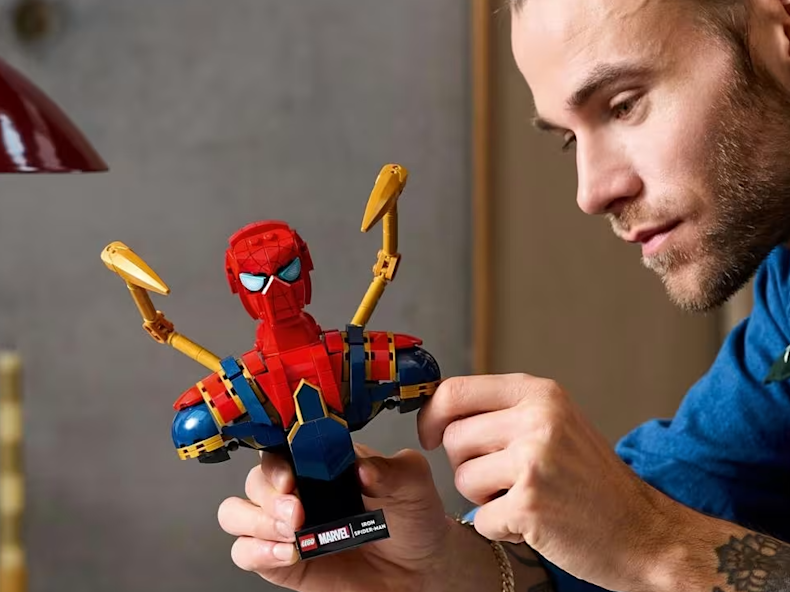 Adult male building spiderman lego set