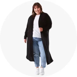 a woman in a black maxi cardigan with blue jeans a white