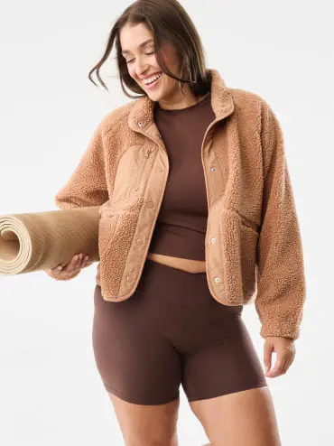 a woman in an activewear set with a brown sherpa active ja