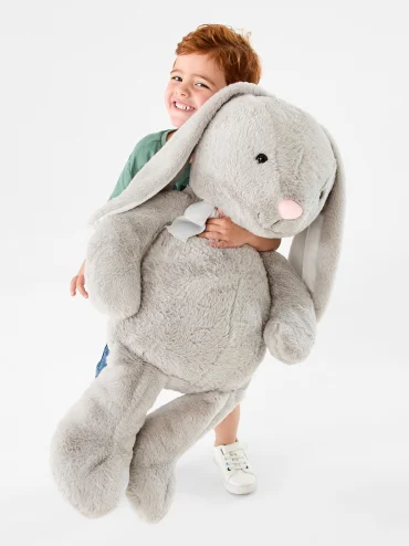 Little boy cuddling a large sized Easter bunny plush