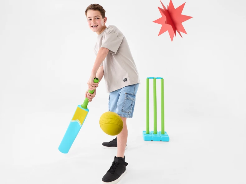 Teenage boy playing with a Beach Cricket Set