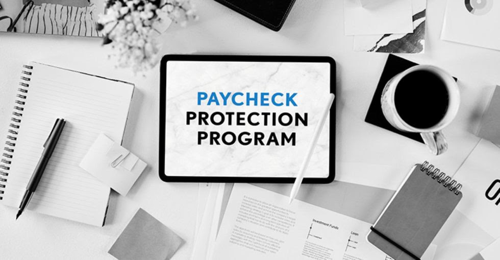 Black and white photo of an office desk with the words "Paycheck Protection Program" in blue and black font.