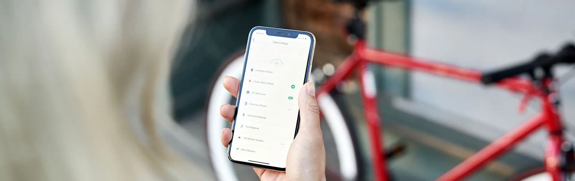 A person using the Tile app in front of a bike