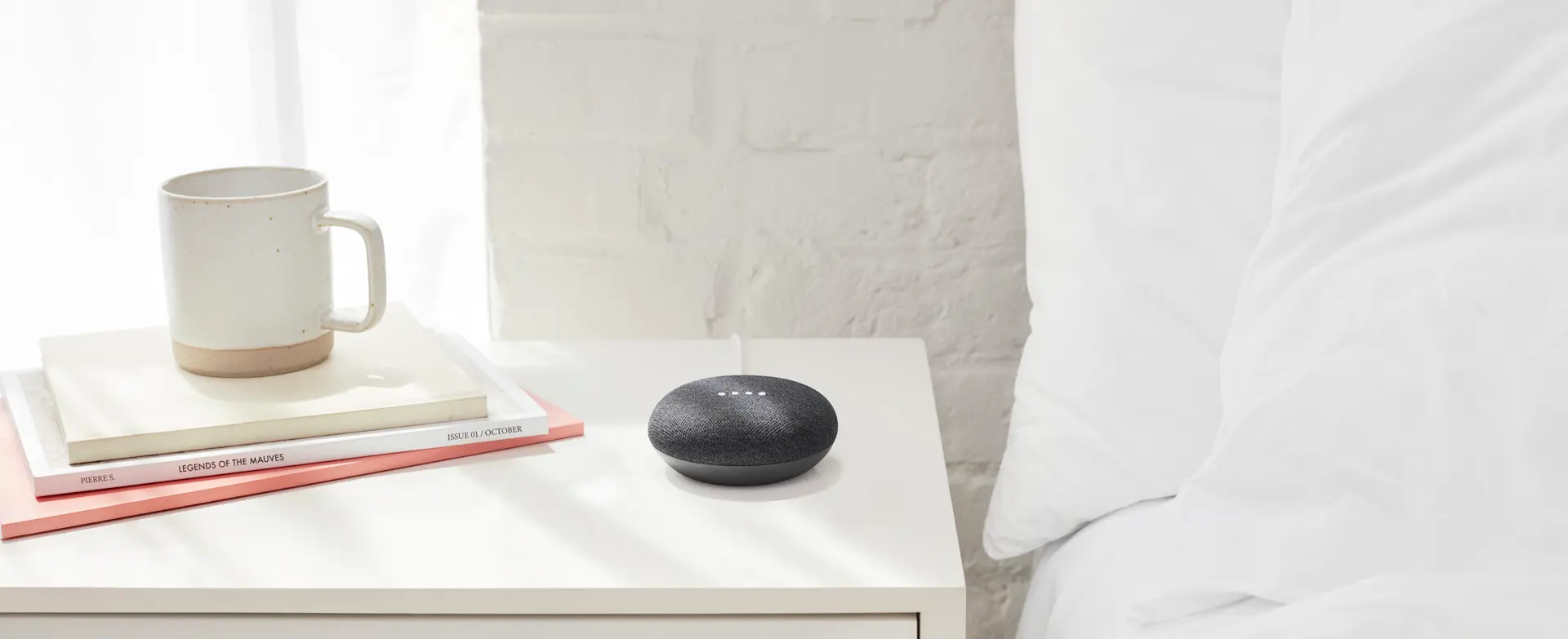 A Google nest mini on a bedside table