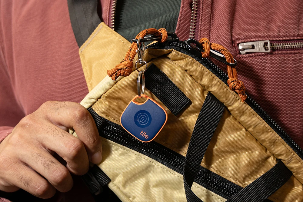 A Tile Mate Navy Blaze attached to a yellow bag.