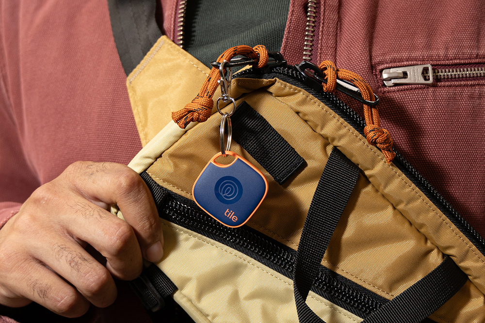 A Tile Mate Navy Blaze attached to a yellow bag.