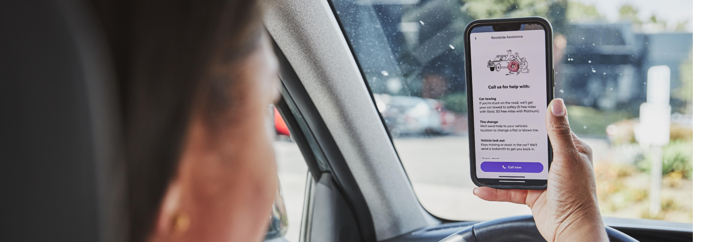 Woman looking at Life360 on her phone in the car