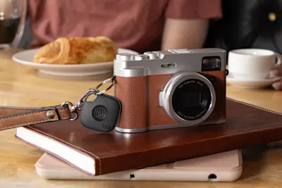 A Life360 Tile attached to a camera.