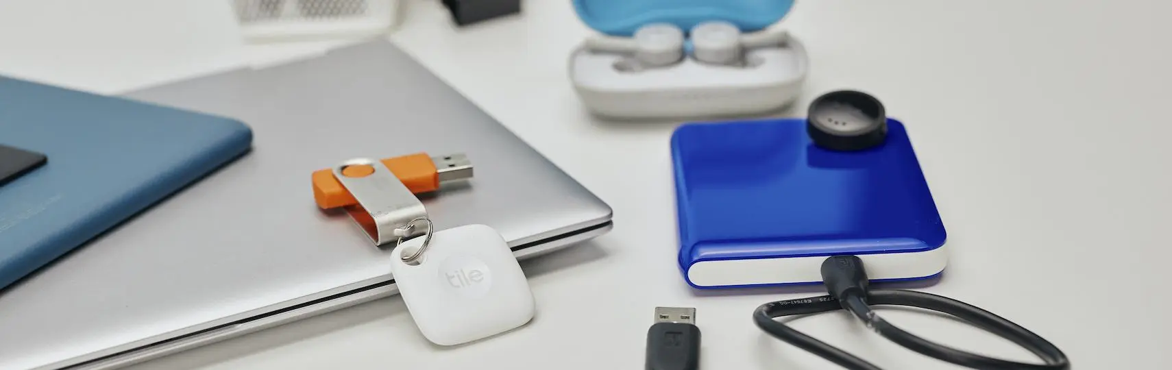 A Tile mate attached to a USB key and a tile sticker on a portable USB drive