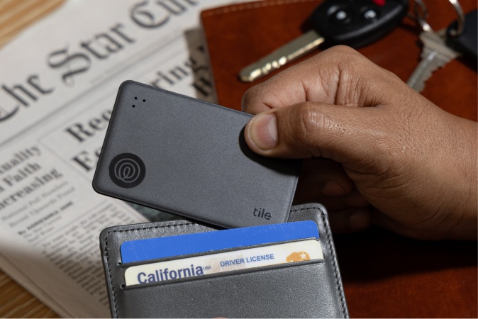 A Tile Slim Black placed inside a person's wallet.