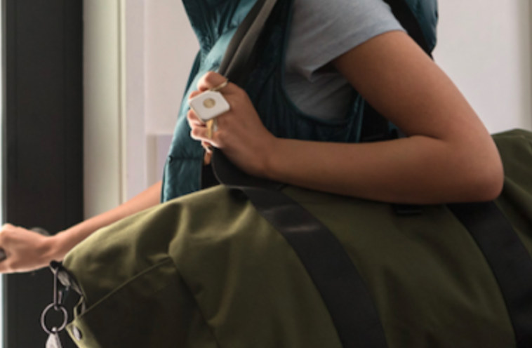 A person holding a bag with a Tile attached