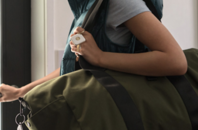A person holding a bag with a Tile attached