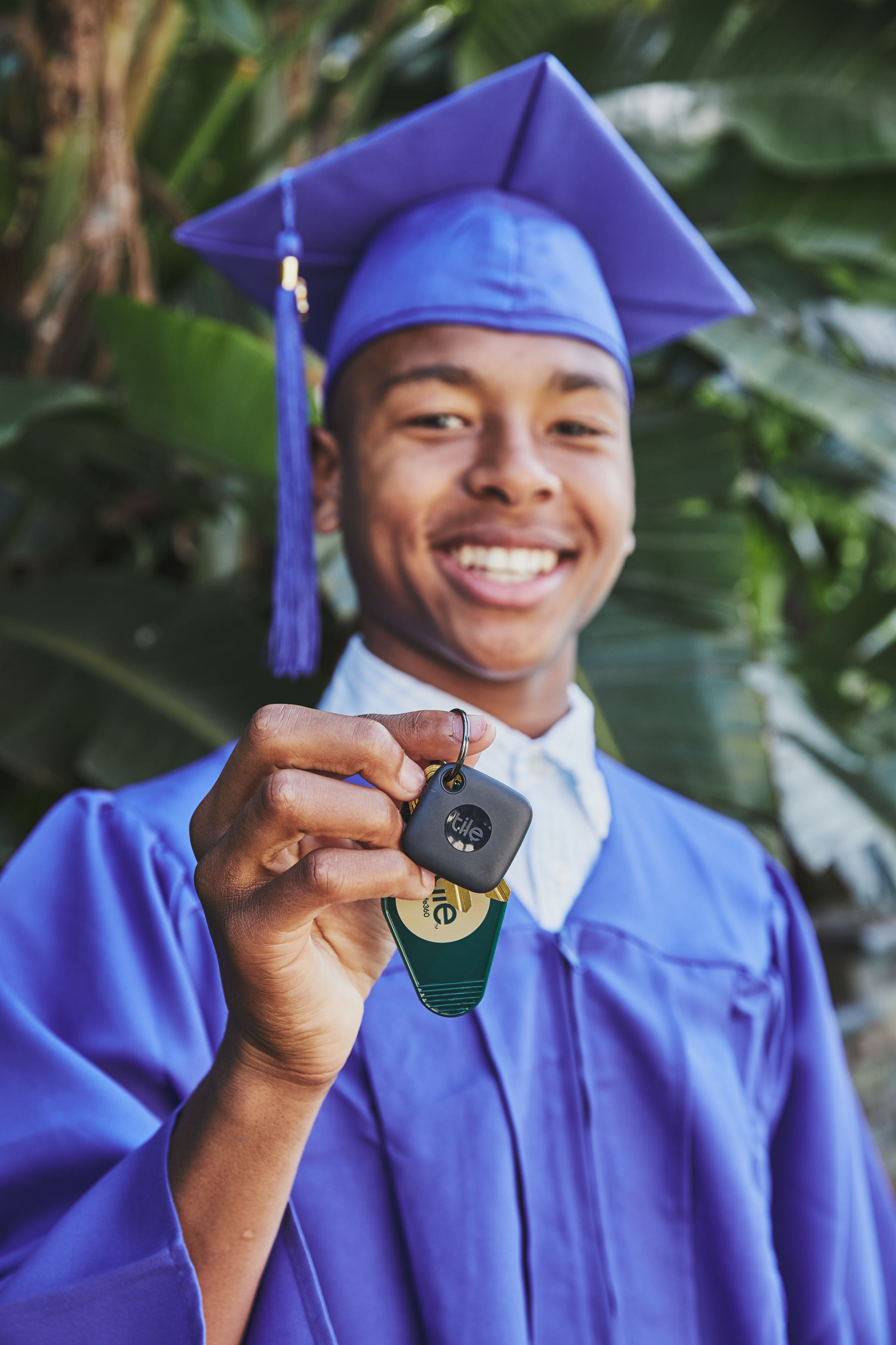 a-person-in-a-graduation-cap-and-gown-smiling-and-holding-keys-with-a
