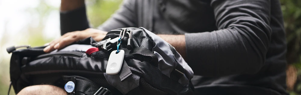 A person with a Tile pro attached to their backpack
