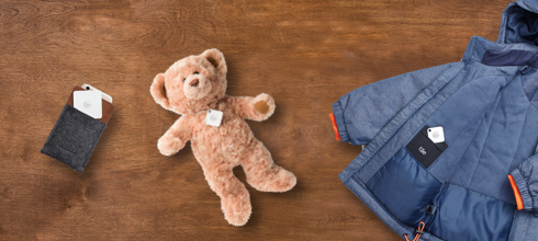 A plush bear, a jacket and wallet with Tiles attached