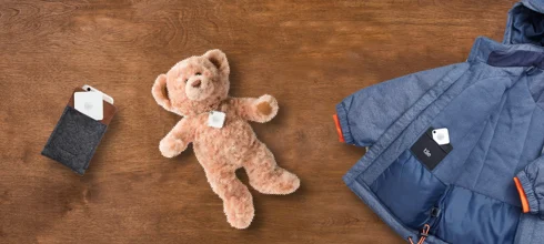 A plush bear, a jacket and wallet with Tiles attached