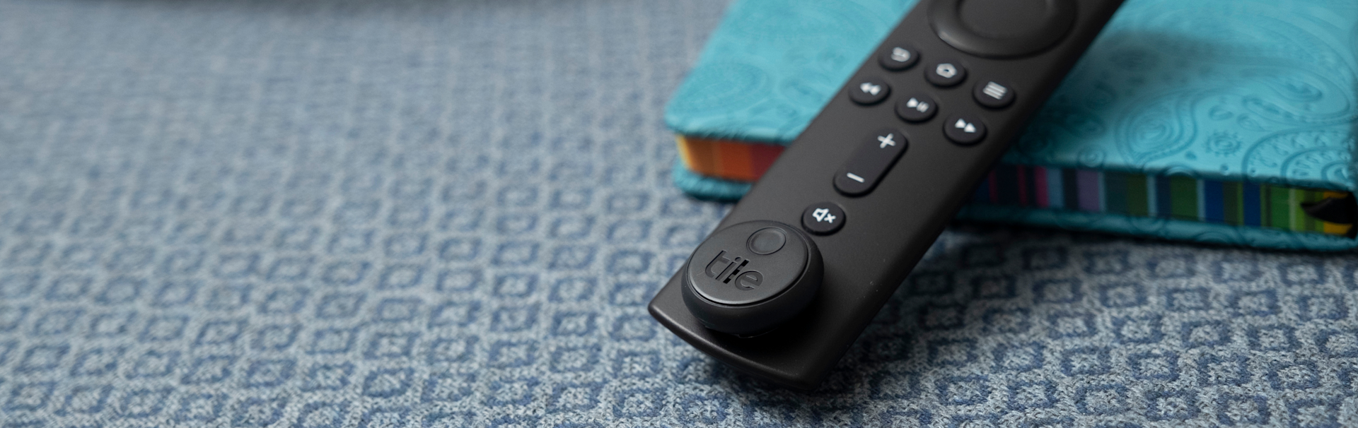 A remote with a Tile sticket attached