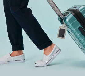 A person with a Tile slim attached to their luggage
