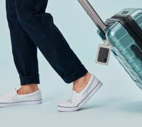 A person with a Tile slim attached to their luggage