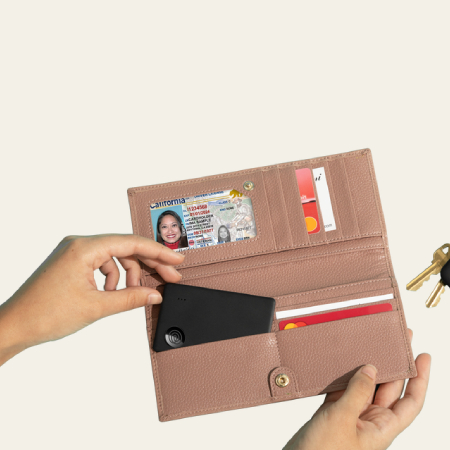 A Tile Slim Black placed inside a leather passport holder.