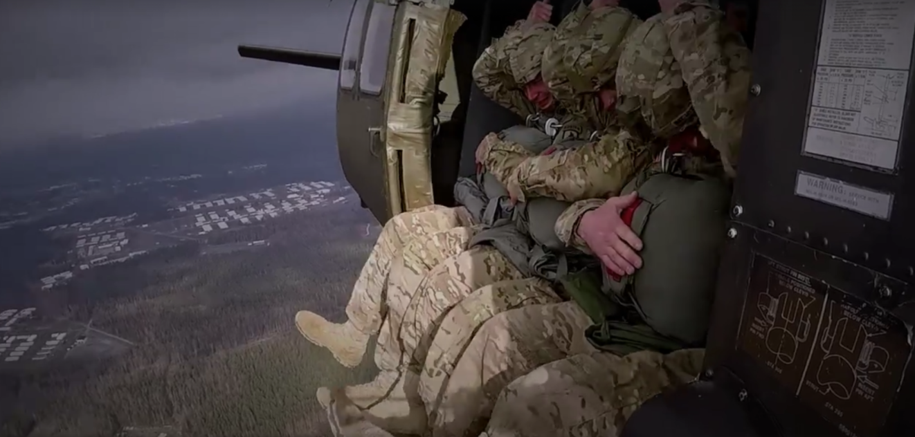 A paratrooper sitting in a helicopter ready to jump