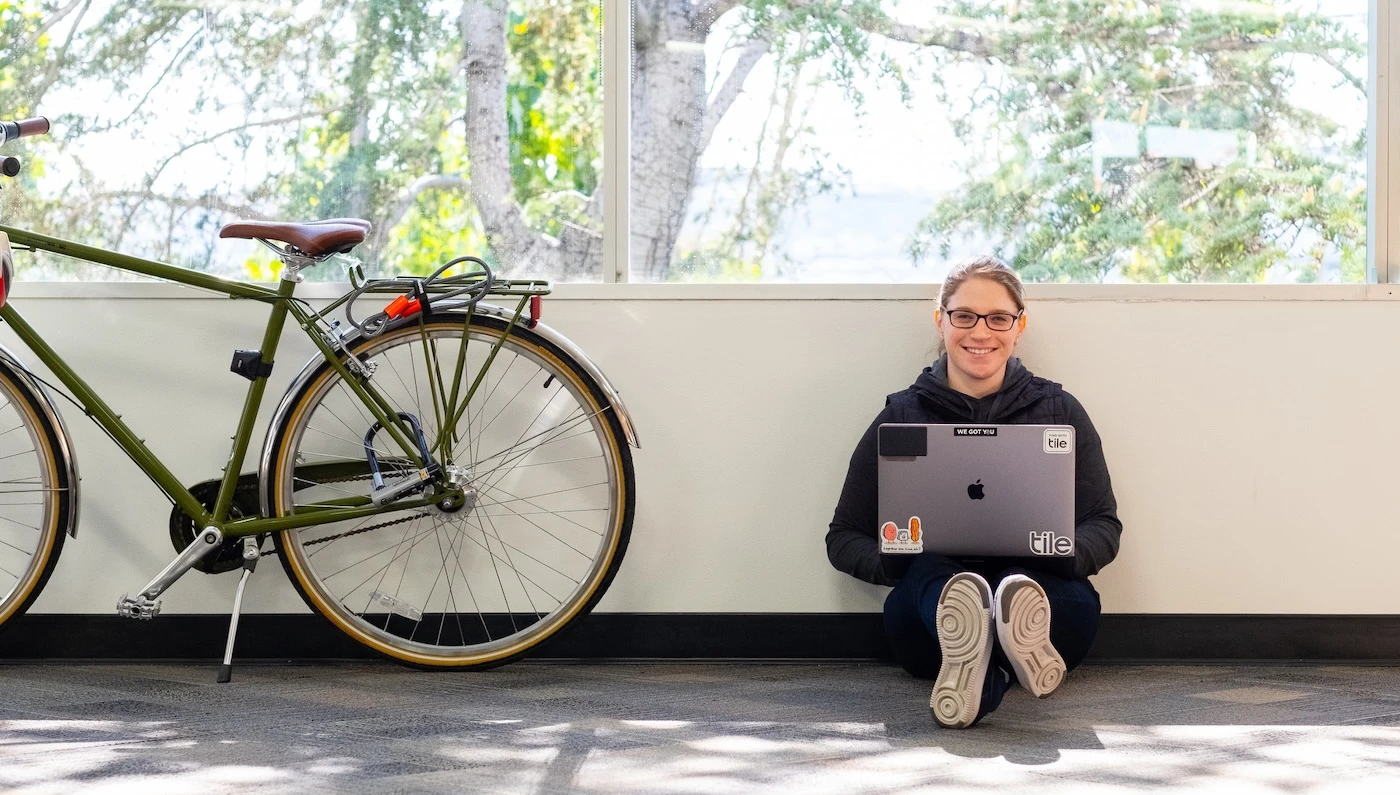 A Tile employee with a laptop on their lap
