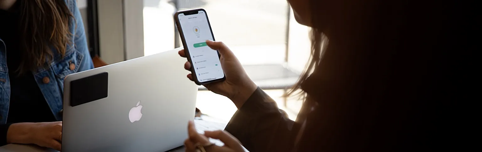 A laptop with a Tile attached and a phone using the Tile app