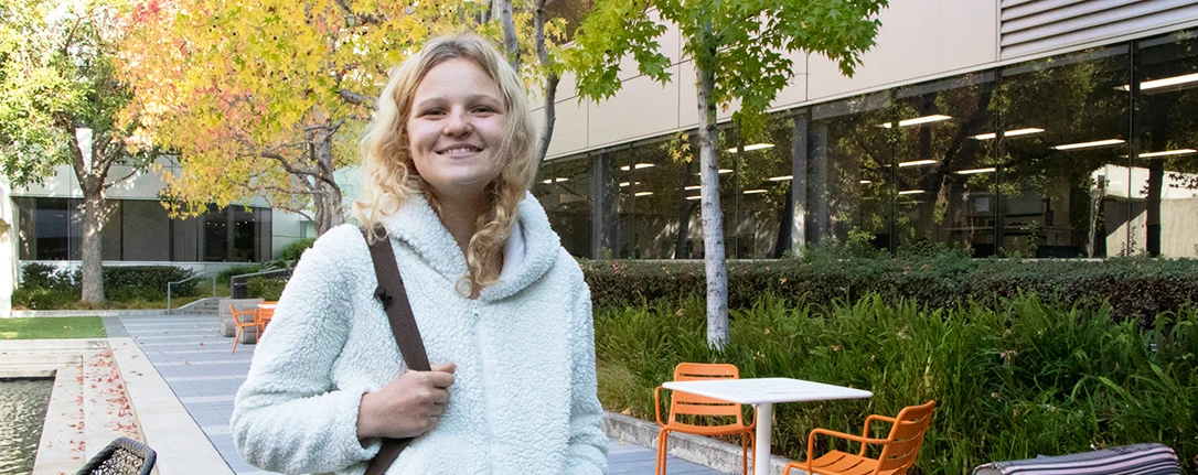 A smiling person in a courtyard