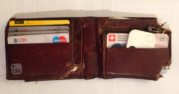 A chewed up wallet with a Tile in it