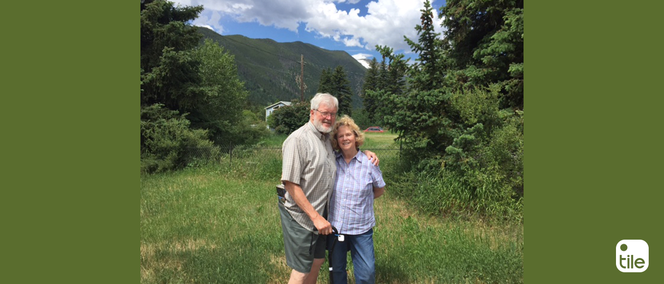 Two people posing with a Tile attached to a cane