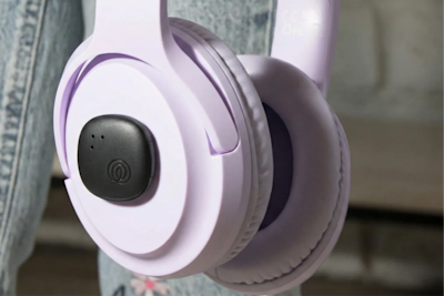 A Life360 Tile Sticker - Black placed on purple headphones 