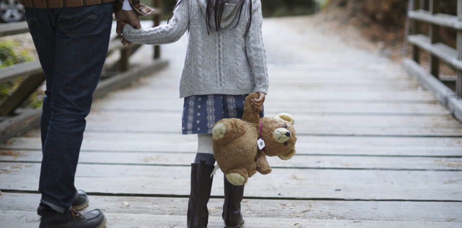 A person holding a plush bear with a Tile attached