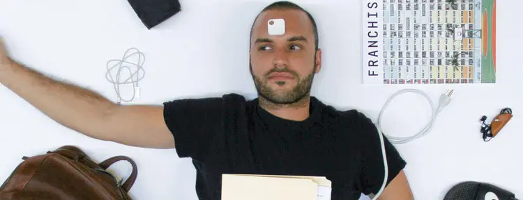 A person lying down with a Tile on their forehead
